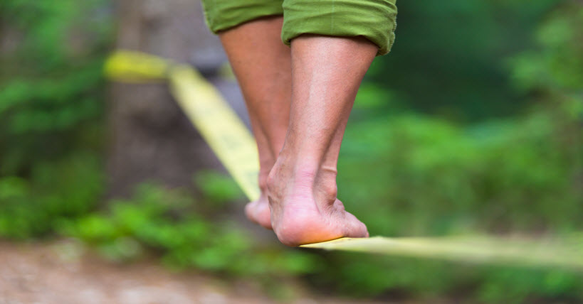 close up of man's feet while slacklining